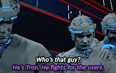 Scene from Tron, with one program asking, 'Who's that guy?' and another responding 'He's Tron. He fights for the users.'